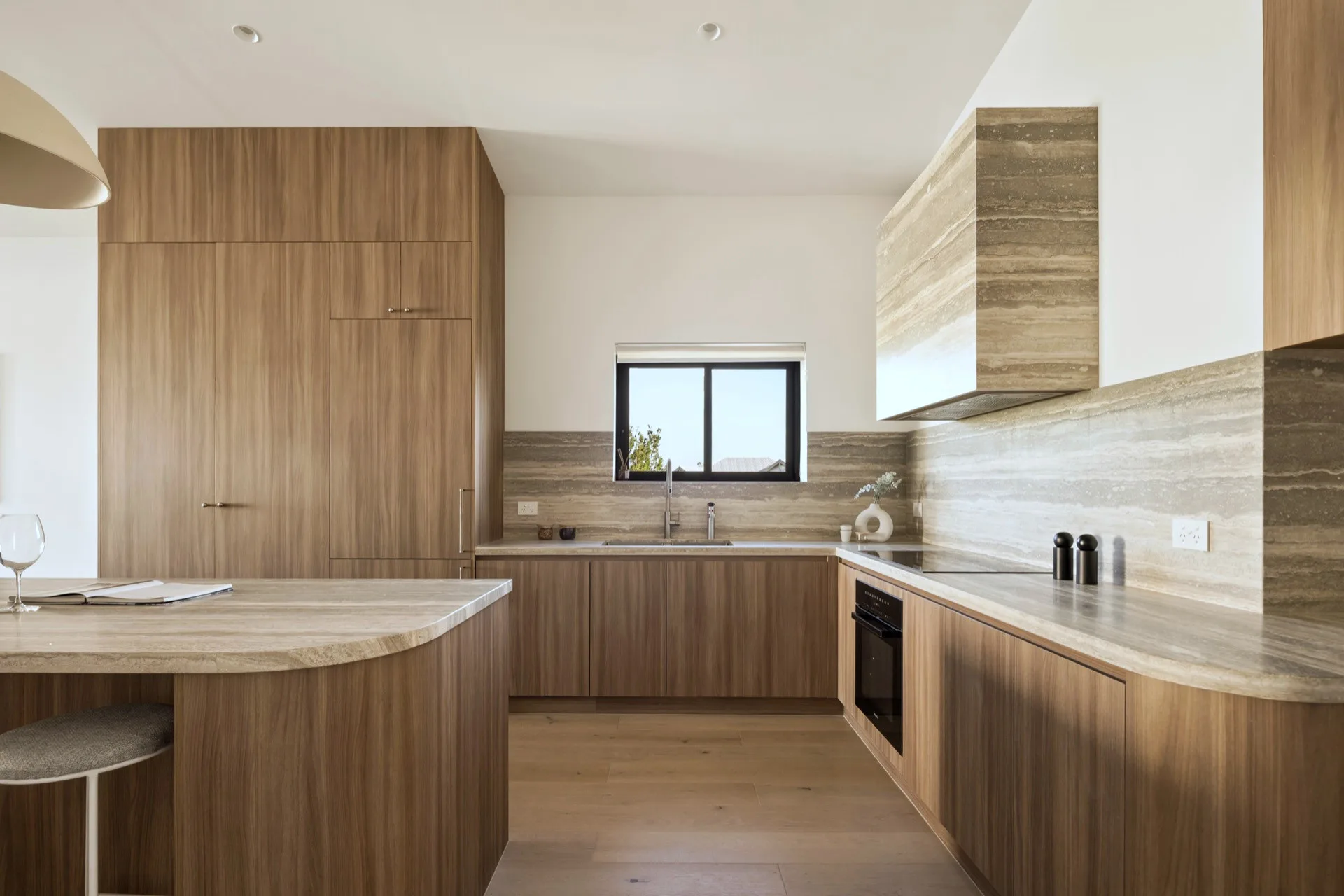 The kitchen, travertine against dark timber